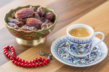 Turkish coffee, dates, and red rosary on table side view