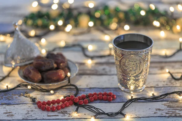 Fechas, rosario y copa de agua con el texto de Allah en árabe en luces — Foto de Stock