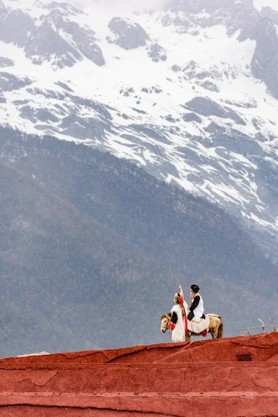 Pareja apuntando a la montaña de nieve, China — Foto de Stock