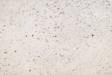 Doğal çatlakları ve delikleriyle pürüzlü beton duvar yüzeyi.