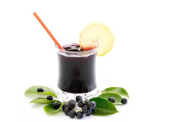 Chokeberry 黑楸楸 的鲜汁在玻璃和浆果和叶子附近 被隔绝在白色背景上 图库图片