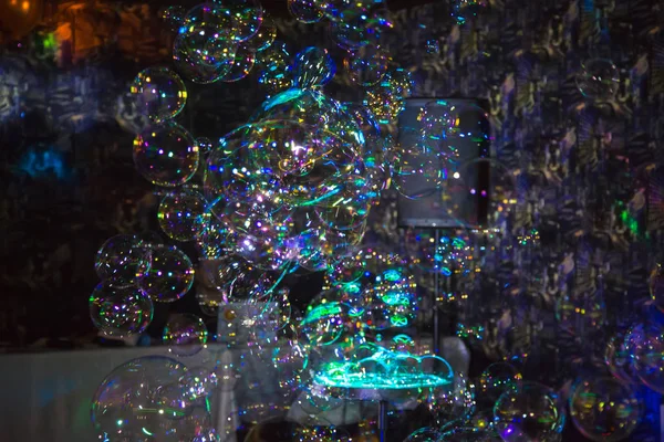 Many beautiful multi-colored bubbles. Festive show. Blurred background. Holiday, anniversary, birthday.