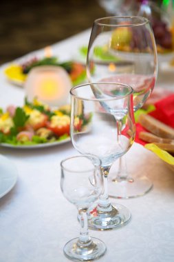 Şarap ve su tatil masada boş bardak. Kutlama bir ziyafet hizmet. Noel, Doğum günü. Mumlar ve aperatifler masanın üzerinde. Arka plan bulanık.