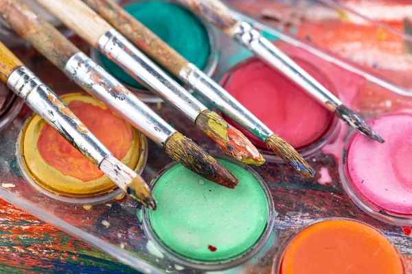 Paint brushes and paints for drawing.