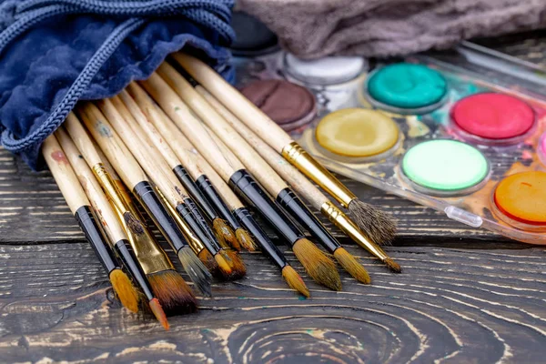 Paint brushes and paints for drawing.