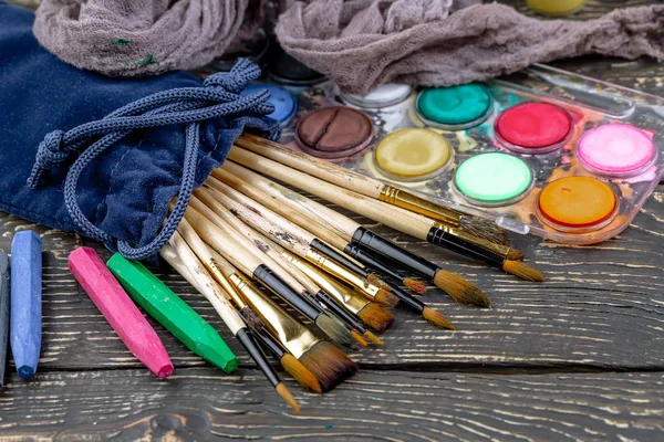 Paint brushes and paints for drawing.