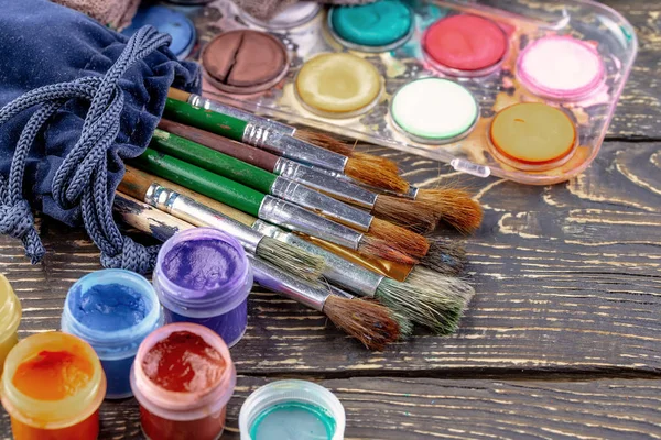 Paint brushes and paints for drawing.