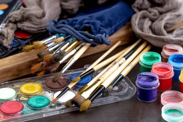 Paint brushes and paints for drawing.