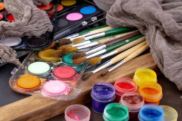 Paint brushes and paints for drawing.