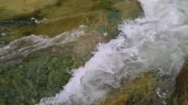 Yazın dağlarda bir dağ nehrinin kaynayan suları