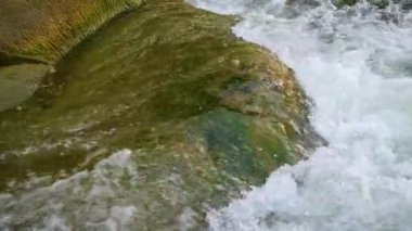 Yazın dağlarda bir dağ nehrinin kaynayan suları