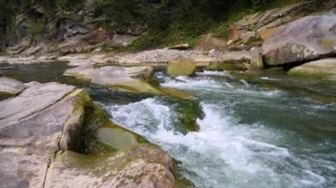 Yazın dağlarda bir dağ nehrinin kaynayan suları