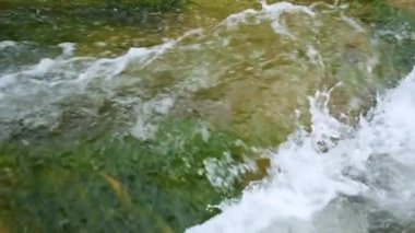 Yazın dağlarda bir dağ nehrinin kaynayan suları