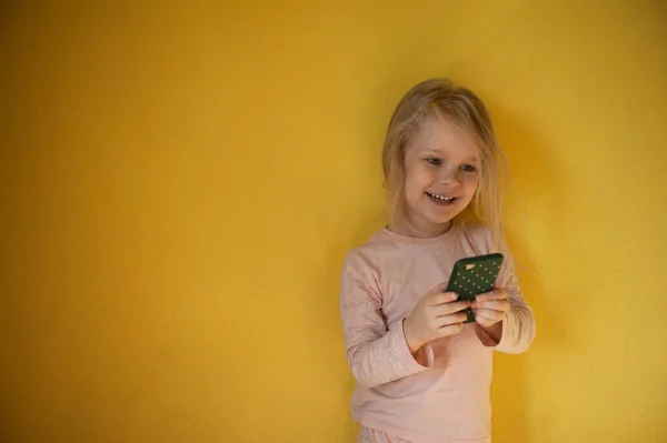 Маленькая девочка держит телефон в руках — стоковое фото