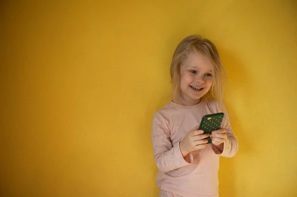 Niña sosteniendo un teléfono en sus manos —  Fotos de Stock