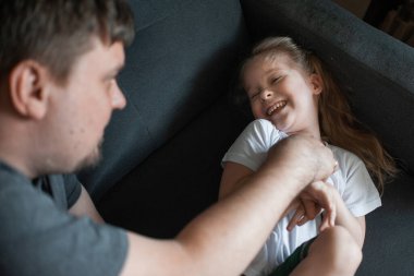 Baba çocuklarıyla evde oynar: kızları, oğulları.