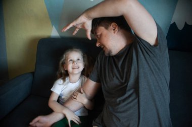 Baba çocuklarıyla evde oynar: kızları, oğulları.