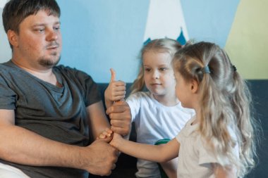 Baba kızıyla oynuyor. Baba ve kızları gösteri sınıfı. Baba ve çocuklar parmaklardan bir kule inşa ediyorlar.