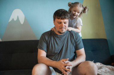 Baba çocuklarıyla evde oynar: kızları, oğulları.