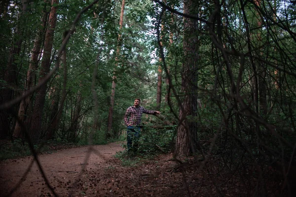 A man walks through the coniferous forest — Stock Photo, Image