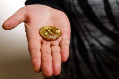 Altın bitcoin, sanal para kavramı tutan el
