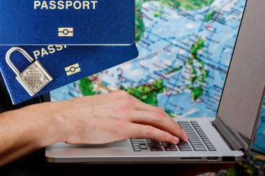 Laptop ile akıllı saat pasaport kredi kartı ve arka planda akıllı telefon üzerine erkek eller