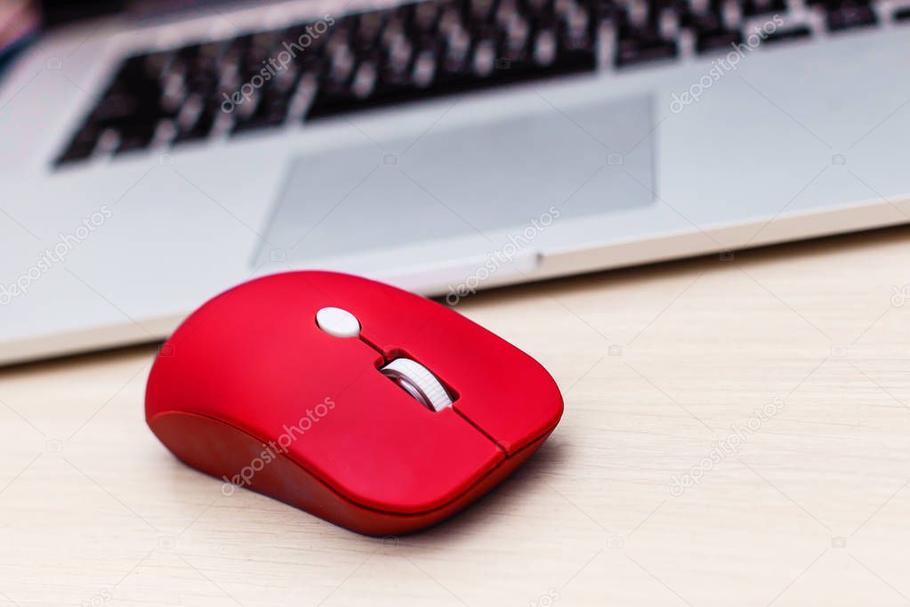 Red mouse on laptop keyboard background
