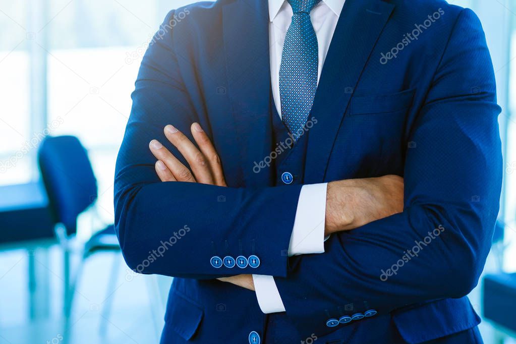 Portrait of happy businessman with arms crossed standing in office