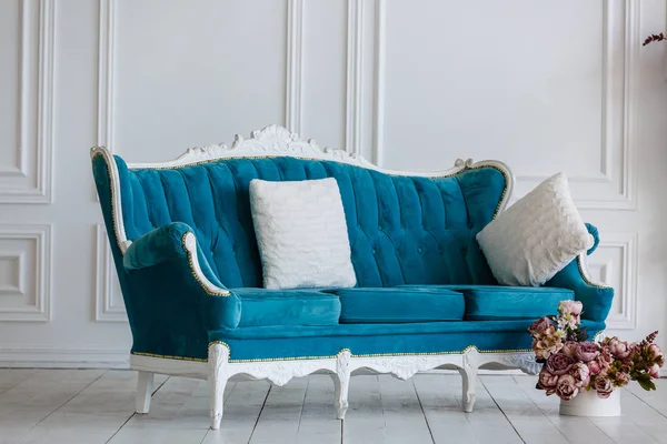 Classic blue sofa in luxurious white room. artificial fireplace