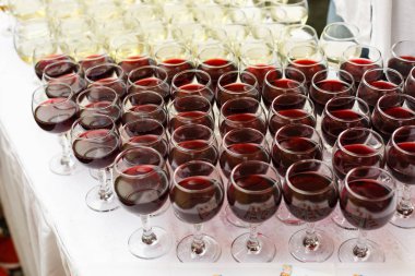 Bardakta kırmızı şarap. Sığ alan derinliği.