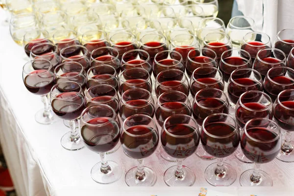 Bardakta kırmızı şarap. Sığ alan derinliği.