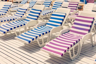 Tatil yüzme havuzunda yakınındaki beyaz ve mavi çizgili şezlong.