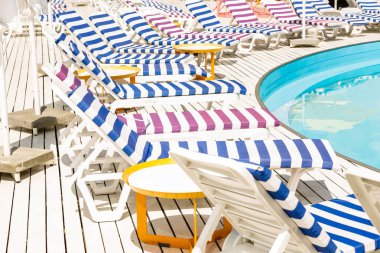 Tatil yüzme havuzunda yakınındaki beyaz ve mavi çizgili şezlong.