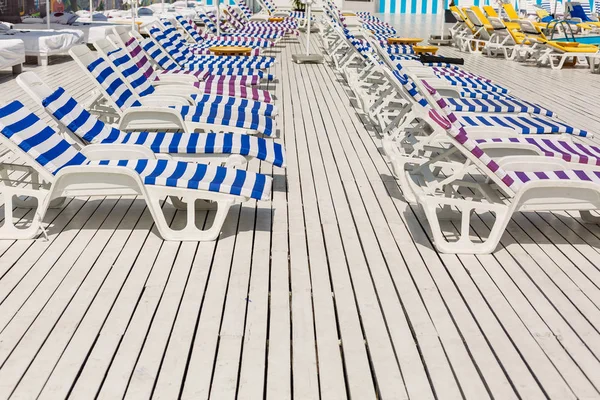 Tatil yüzme havuzunda yakınındaki beyaz ve mavi çizgili şezlong.