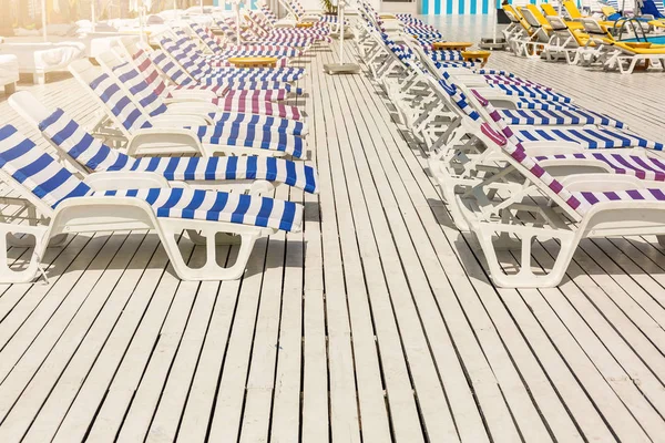 Tatil yüzme havuzunda yakınındaki beyaz ve mavi çizgili şezlong.