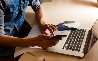 üzerinde boş ekran dizüstü dizüstü pasaport arka plan üzerinde adam holding telefon ve işaret 