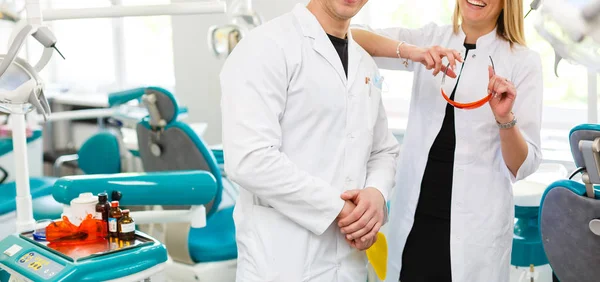 自信的男性和女性牙医 微笑着看着相机的牙科诊所的肖像 — 图库照片