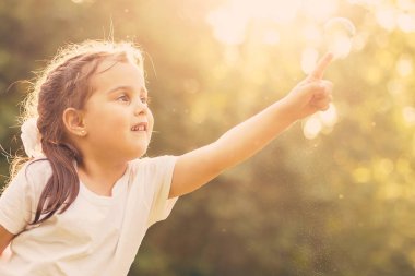 küçük kız açık havada büyük annesi ile sabun köpüğü üfleme