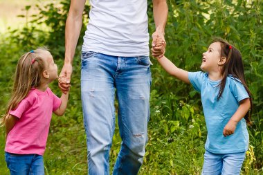 zevk bahar yürüyüşte iki gülümseyen çocuk kızı ile Peder. Aile iki kız kardeş mutlu ile birlikte
