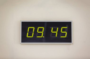 Saat 9.45 gösterilen beyaz bir arka plan üzerinde siyah dijital saat