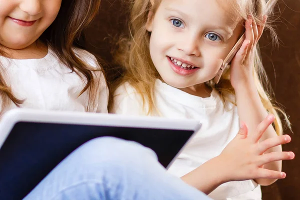 Twee Kleine Meisjes Met Behulp Van Touchpad Smartphone Zittend Bank — Stockfoto