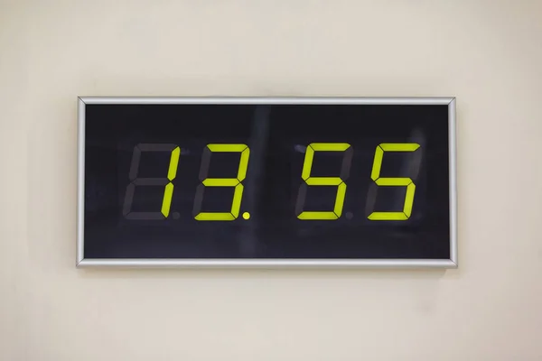 Black digital clock on a white background showing time thirteen hours 55 minutes