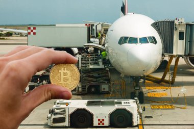 Altın bitcoin uçak arka planda tutan el