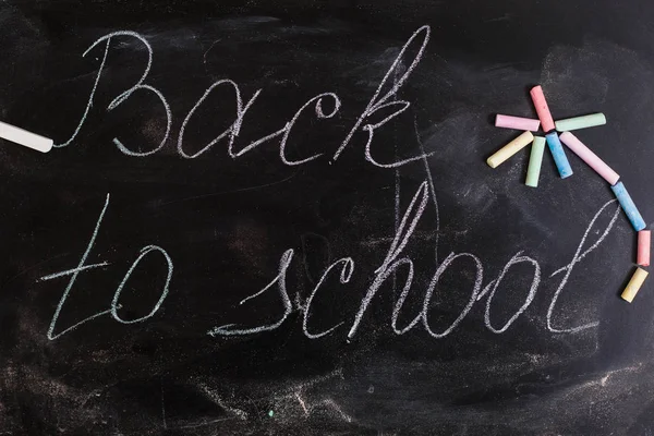 Colorful wallpaper pattern with colored chalks on blackboard back to school concept background