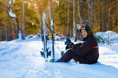 Skier sitting on snow relaxing
