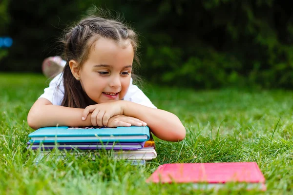 Ein Kleines Mädchen Liegt Auf Dem Bauch Und Liest Gras — Stockfoto