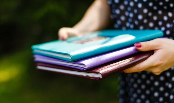 girl holding pile of books in hands, close up