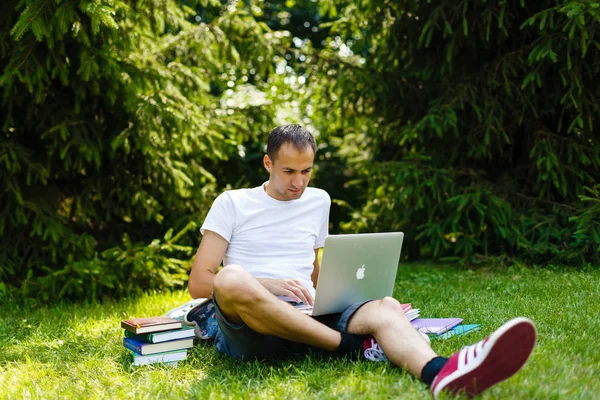 夏天的时候在公园里用笔记本电脑的帅哥 — 图库照片