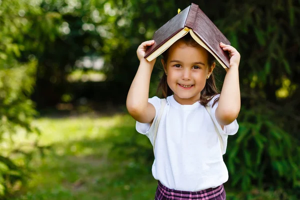 Mädchen Mit Buch Über Dem Kopf Freien Schulmädchenporträt Bildungskonzept Glücklich — Stockfoto