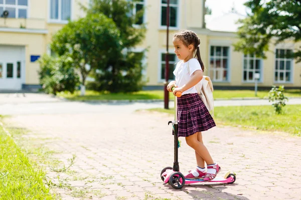 小さな子供は 日当たりの良い夏の日に都市公園にスクーターを乗ることを学習します ローラーに乗ってかわいい女の子 活動的な余暇と子供のための屋外スポーツ — ストック写真